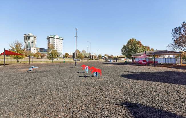 A playground with a red and blue slide and a red canopy structure.