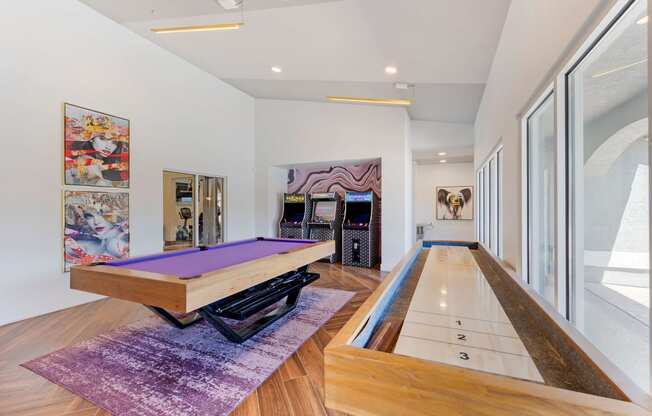 a game room with a pool table and other games in it at Paisley and Pointe Apartments, Las Vegas, 89130