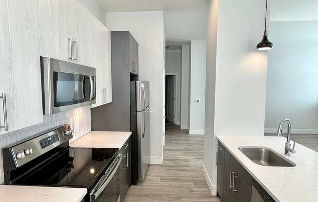 A modern kitchen with dark wood cabinets and stainless steel appliances.