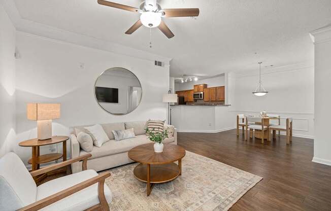 A living room with a white couch, a wooden coffee table, and a ceiling fan.