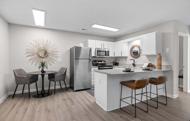 A kitchen with a table and chairs.