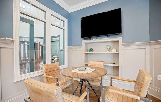 A room with a table and chairs and a television.