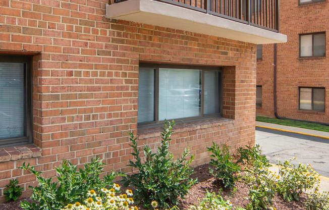 a flower bed in front of a brick building