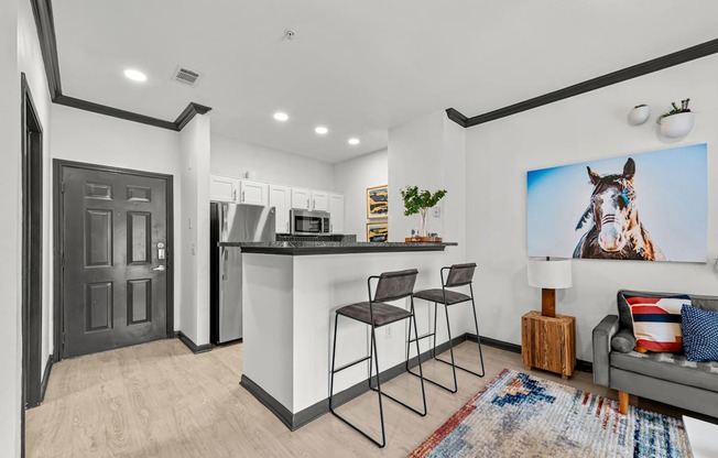 A modern kitchen with a bar area and a large painting of a horse on the wall.