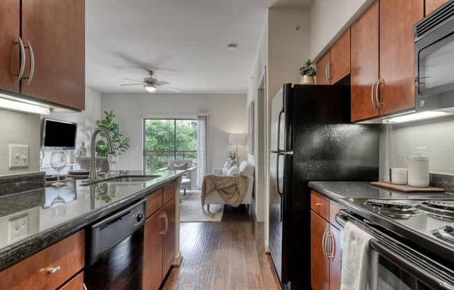 an open kitchen with black appliances and wood cabinets