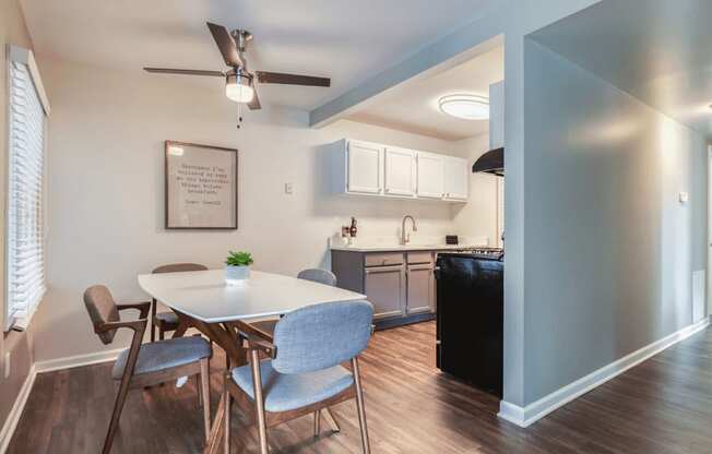 a dining area with a table and chairs and a kitchen in the background at The View Apartments St Charles, St Charles, 60174