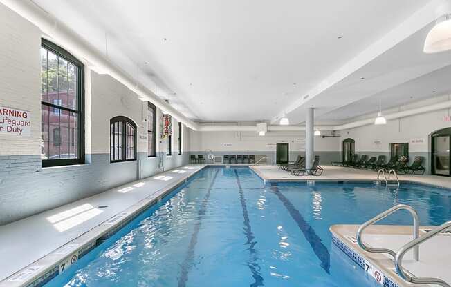 a swimming pool in a building with a blue water floor and at Clocktower and Velvet Mill Apartments, Connecticut