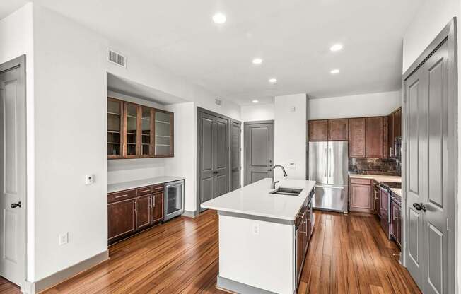 A kitchen with white cabinets and a white island.