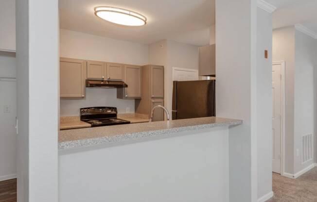 A kitchen with a white counter and brown cabinets.