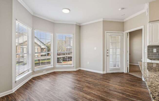 A room with wooden floors and a large window.