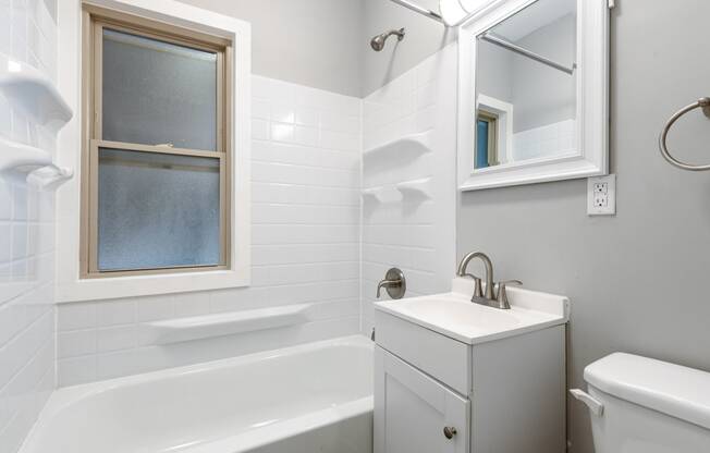 a bathroom with a sink and a tub and a window