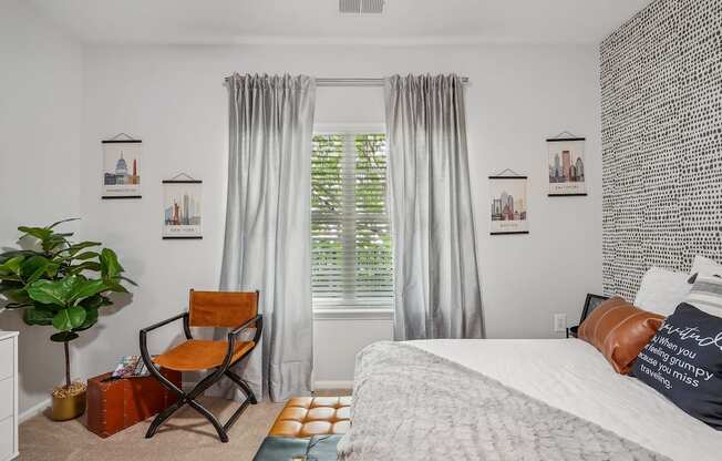 a bedroom with a bed and a window with curtains and a chair
