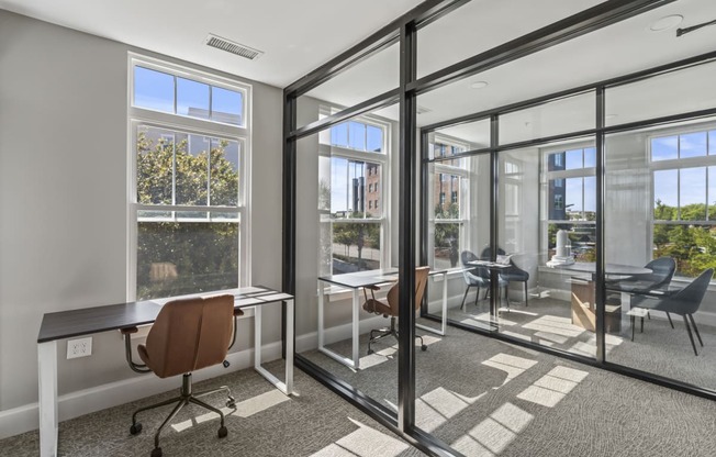 a conference room with glass doors and windows and desks