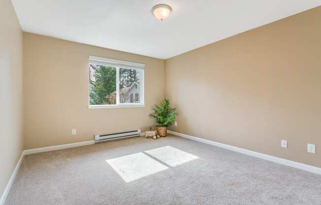 an empty living room with carpet and a window  at Springfield, Renton, WA