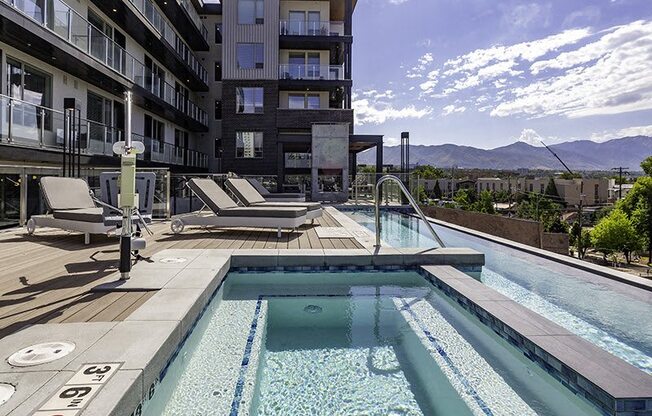 A large outdoor swimming pool with a mountain view in the background.