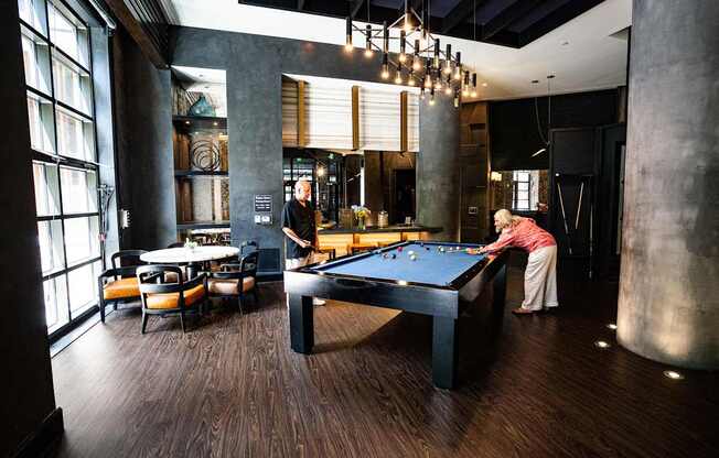 A woman is playing pool in a room with a pool table.