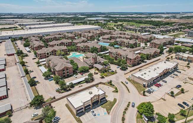 A bird's eye view of a residential area with houses, roads, and vehicles.