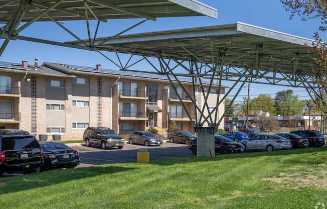 A parking lot with cars and apartment buildings in the background.