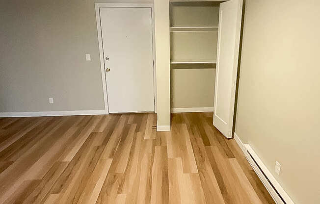 A room with a ceiling fan and wooden flooring.