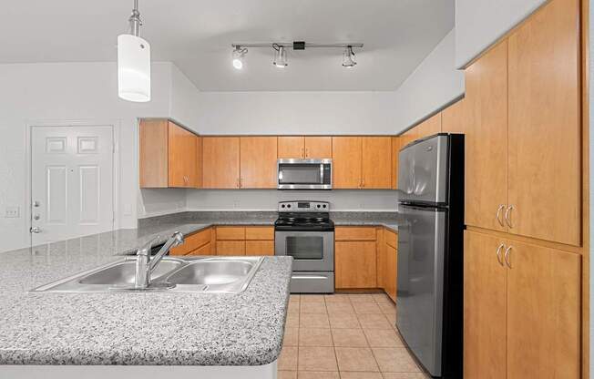 A kitchen with wooden cabinets and a granite countertop.