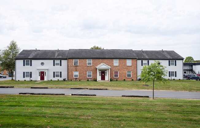 A white building with a red door and windows.