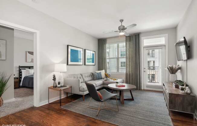 a living room with a couch and a table and a ceiling fan