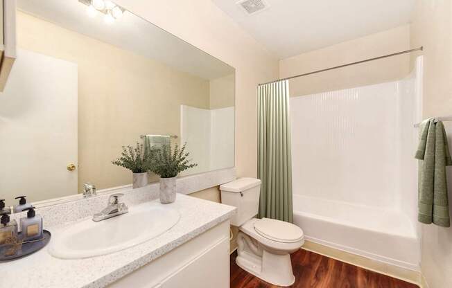 A white toilet sits next to a white sink in a bathroom.