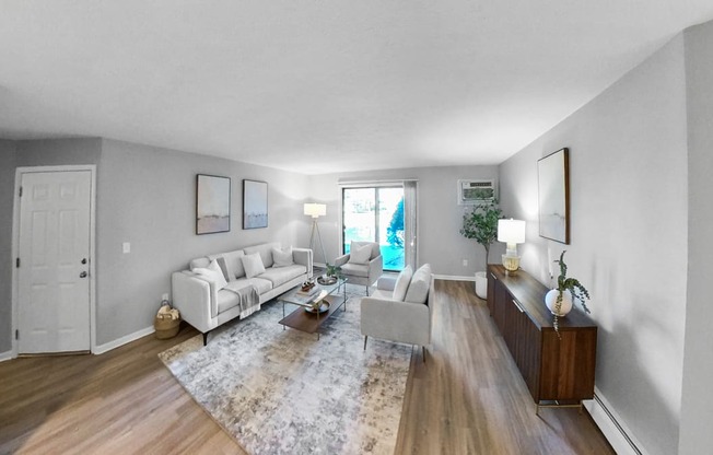 a living room with white couches and a rug