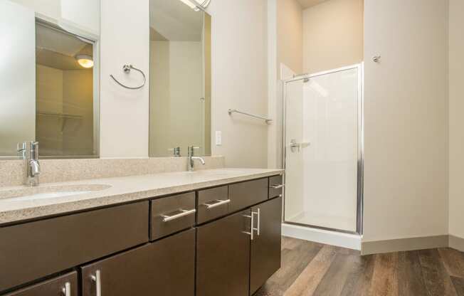 a bathroom with two sinks and a shower