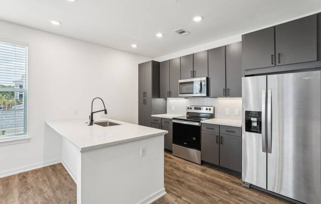 a kitchen with stainless steel appliances and a white counter top at Drift, Daytona Beach, FL, 32117
