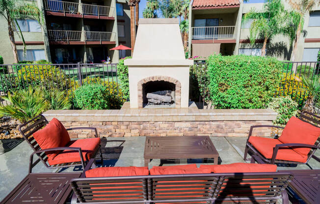 a patio with a fireplace and a table and chairs