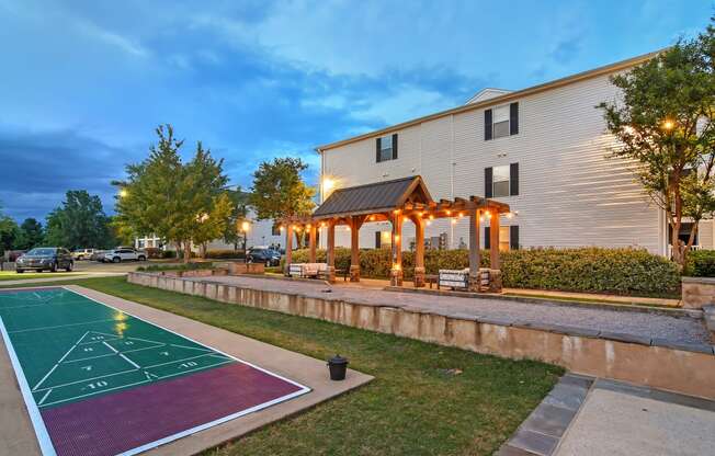 the pavilion at twilight at the community with a basketball court at Avalon Apartment Homes, Starkville, MS