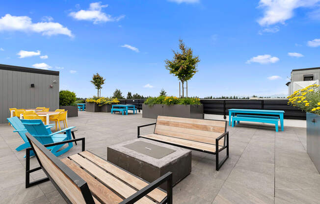 Rooftop Lounge Area with Benches, Blue Adirondack Chairs, and Cozy Firepit at Arabella Apartment Homes, Shoreline, Washington 98155