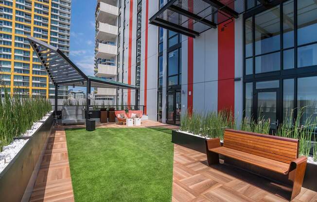 a communal area on the roof of a building with benches and grass