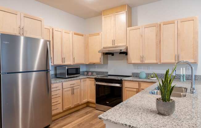 a kitchen with wooden cabinets and granite counter tops and a stainless steel refrigerator