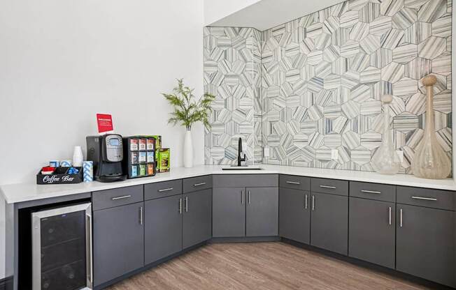 A kitchen with grey cabinets and a white counter top.