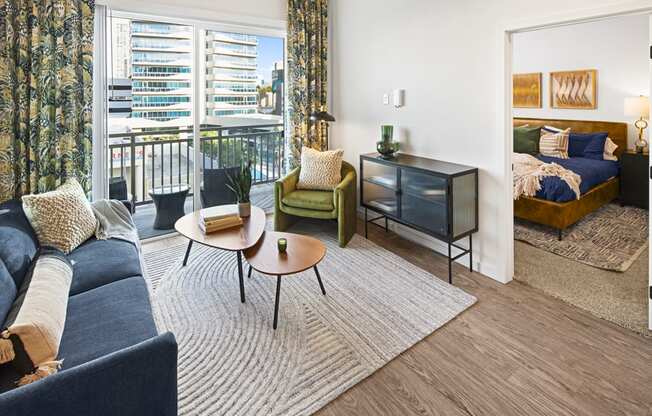 a living room with a couch and a coffee table and a bedroom with a balcony at Aura Vegas Apartments, Las Vegas