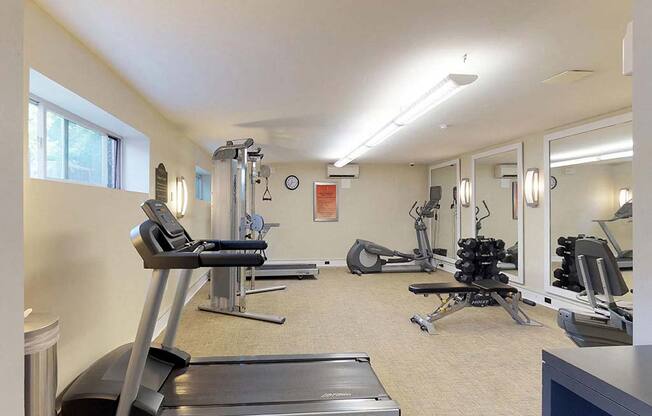 Residential gym area with treadmill and various other types of equipment at Gainsborough Court Apartments, Fairfax