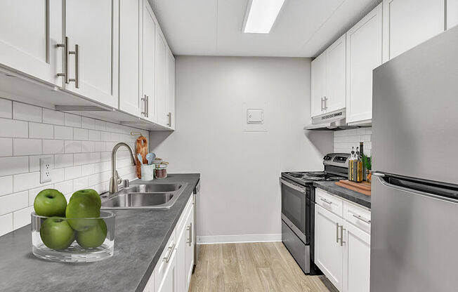 a white kitchen with stainless steel appliances and white cabinets