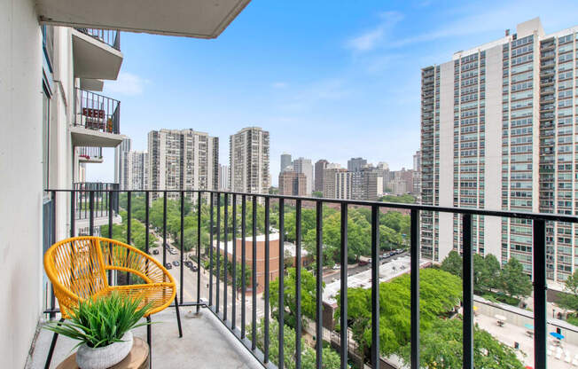 a balcony with a wicker chair and a view of the city