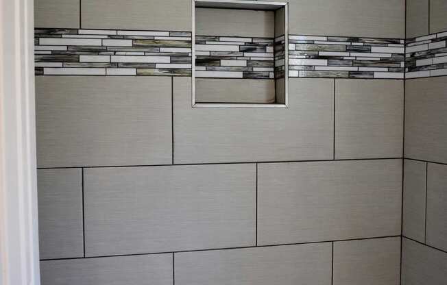 Tub shower combination with tiled surround and inset shelf