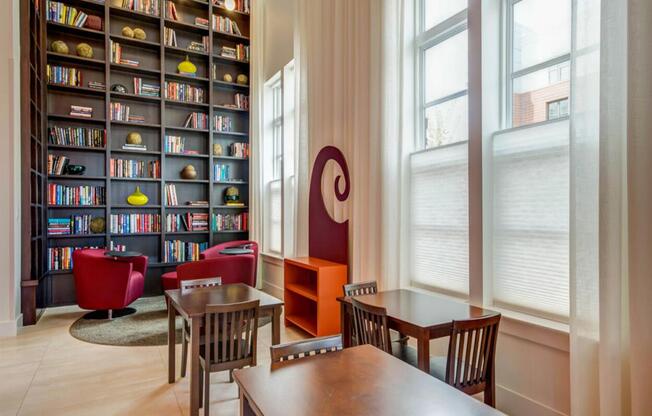 a library with tables and chairs and a large book shelf