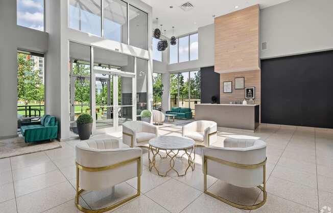 the lobby or reception area of a hotel with chairs and tables