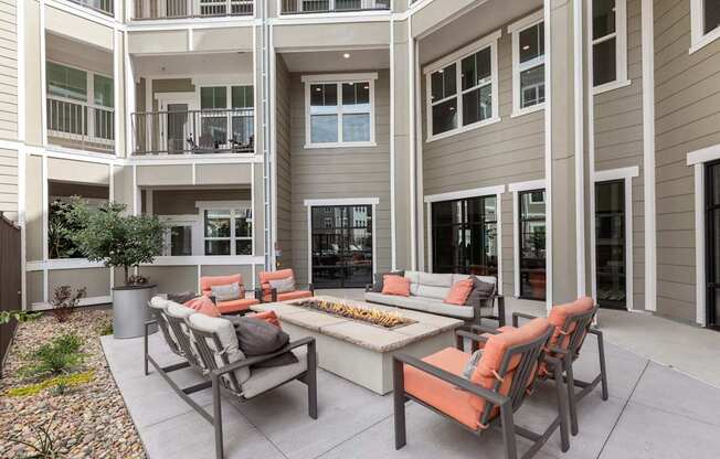 A patio with a table and chairs is in front of a building.