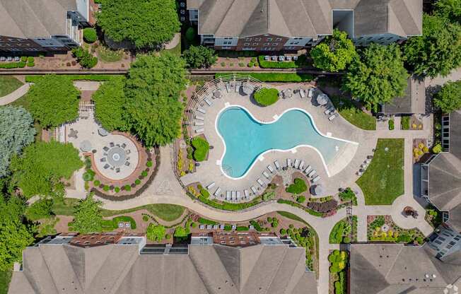 A bird's eye view of a residential area with a swimming pool and a fountain.