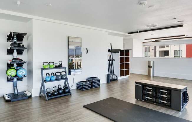 A home gym with a variety of equipment including a treadmill, weights, and a bench press.