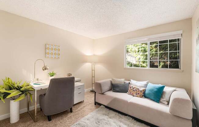 A room with a desk, chair, and couch.