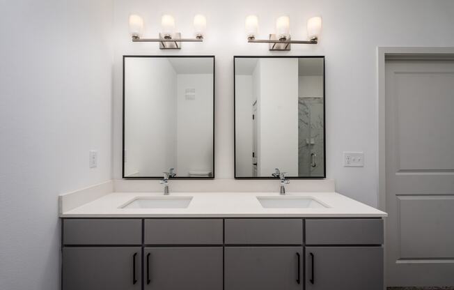 a bathroom with two sinks and two mirrors