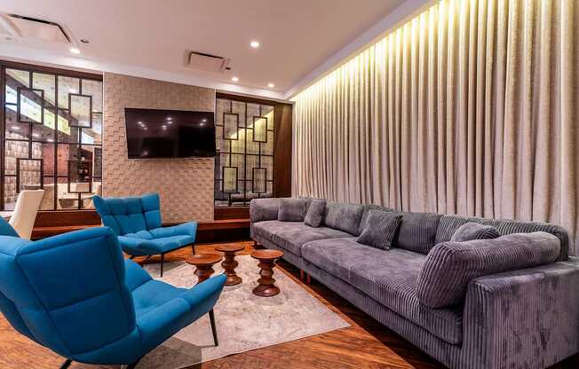 a living room with blue chairs and a gray couch