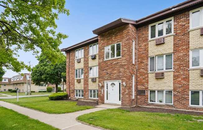 A brick apartment building with a white door and windows.
